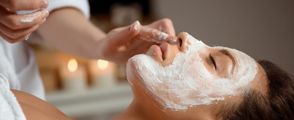 Woman receiving a facial mask application.