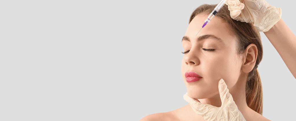 Woman receiving a cosmetic injection in her forehead from a specialist.