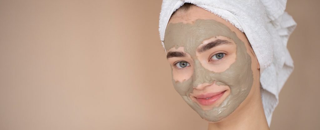 Woman with a gray face mask smiling at the camera.
