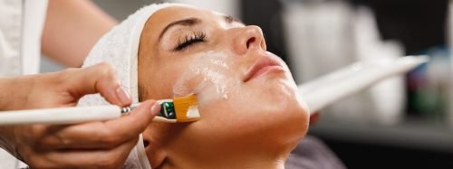 Facial mask being applied with a brush during a skincare treatment.