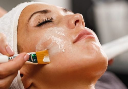 Facial mask being applied with a brush during a skincare treatment.