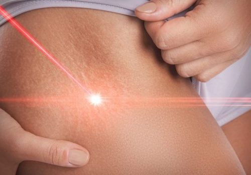 Professional in coveralls holding a hard hat and earmuffs.