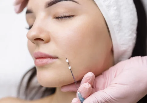 Cosmetic facial injection being performed along the jawline.